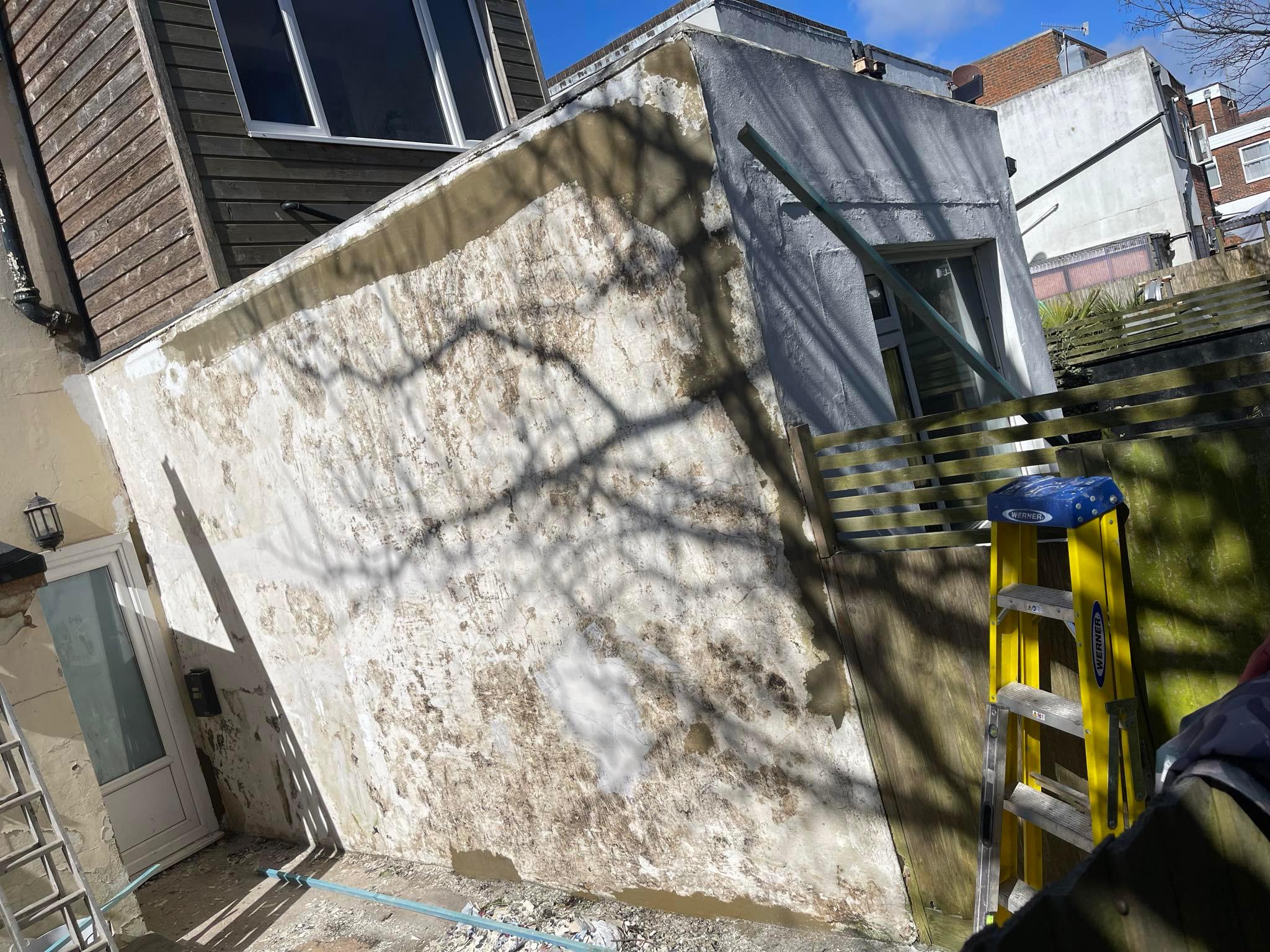 Flaking and damaged exterior render before repair